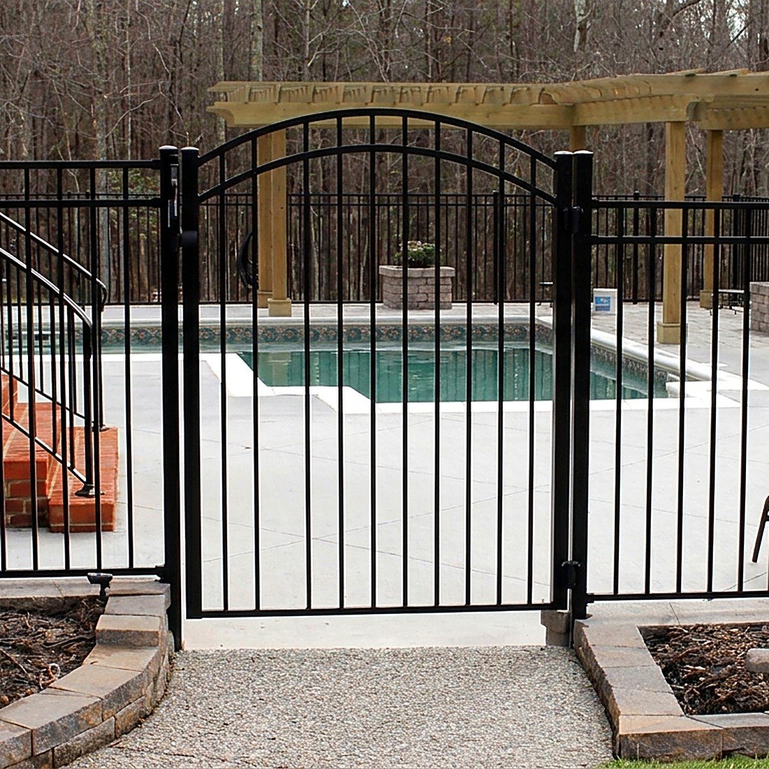 Black aluminum arched gate around a pool