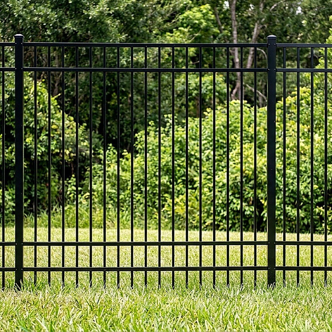 Black aluminum picket fence on a lawn