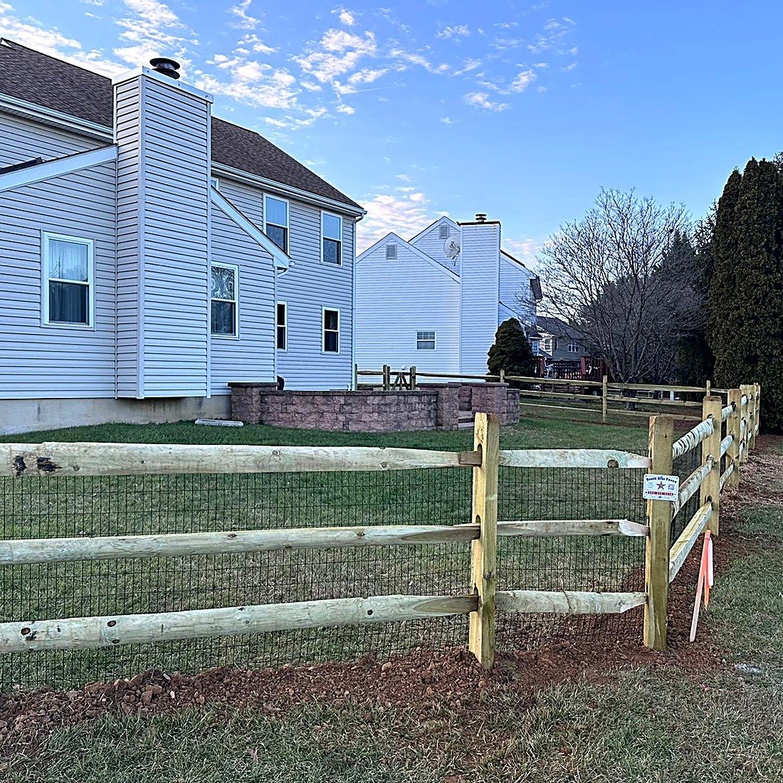 Split rail wood fence installed in a backyard